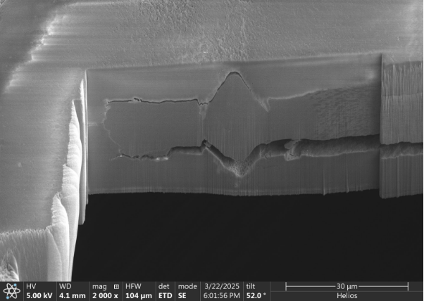 Backscattered-electron image of a FIB-milled cross-section of an X-ray-heated iron-alloy sample, with the original 30 micrometre scale bar.